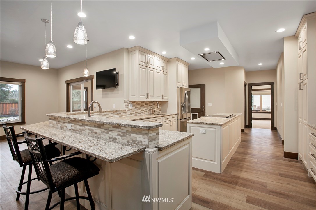 1130 West Axton Road Ferndale, WA 98248 - Photo 20 of 40 a kitchen with stainless steel appliances kitchen island granite countertop a kitchen island and chairs in it