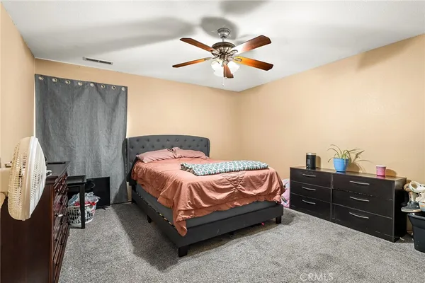 a spacious bedroom with a bed and a chandelier