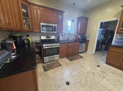 a kitchen with granite countertop a stove a sink and a microwave