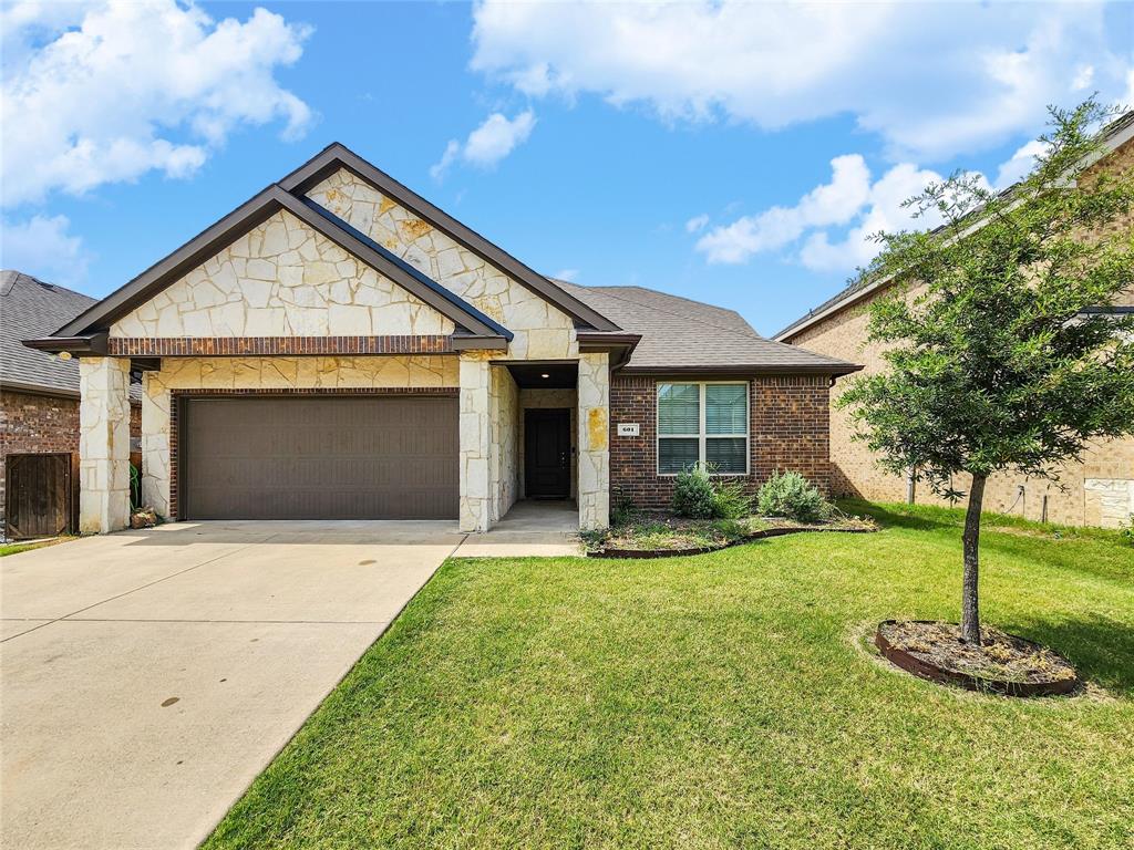 601 Bassett Hall Road Fate, TX 75189 - Photo 1 of 1 View of front of property featuring driveway, brick siding, a front yard, a garage, and stone siding