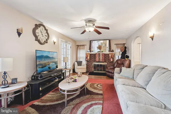 a living room with furniture a clock on wall and a flat screen tv