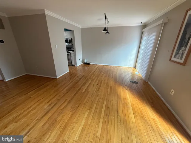 a view of empty room with wooden floor