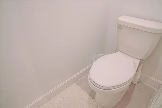a white toilet sitting next to a white wall