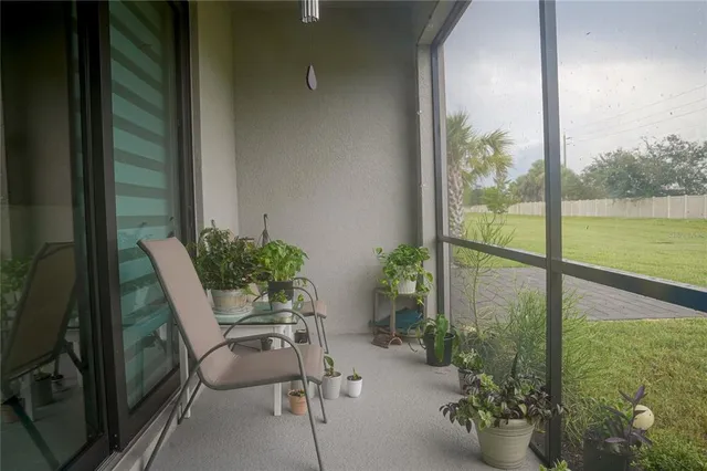 a view of a porch with chairs and potted plants