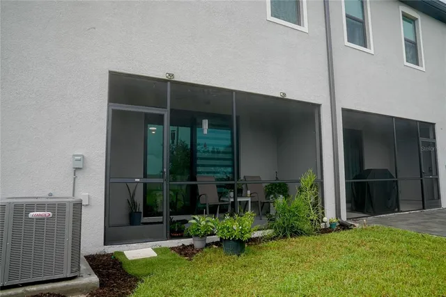 a view of backyard with potted plants and a large window