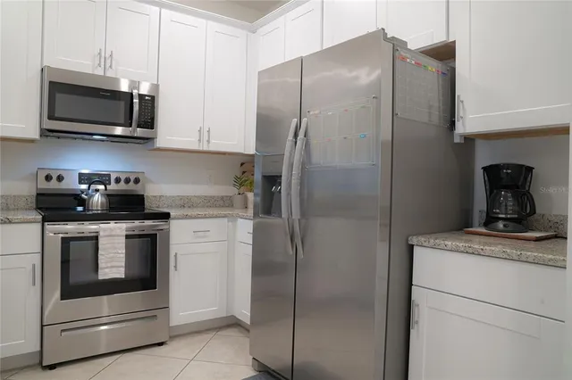 a kitchen with stainless steel appliances granite countertop cabinets and refrigerator