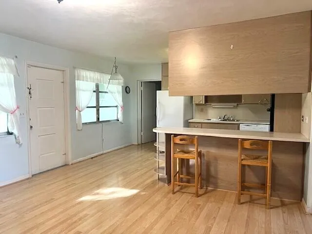 a kitchen with a sink cabinets and wooden floor