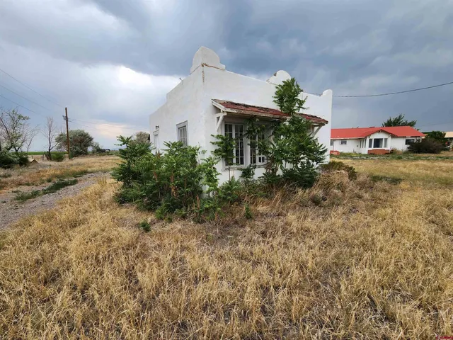 a yellow house with green field in front of it