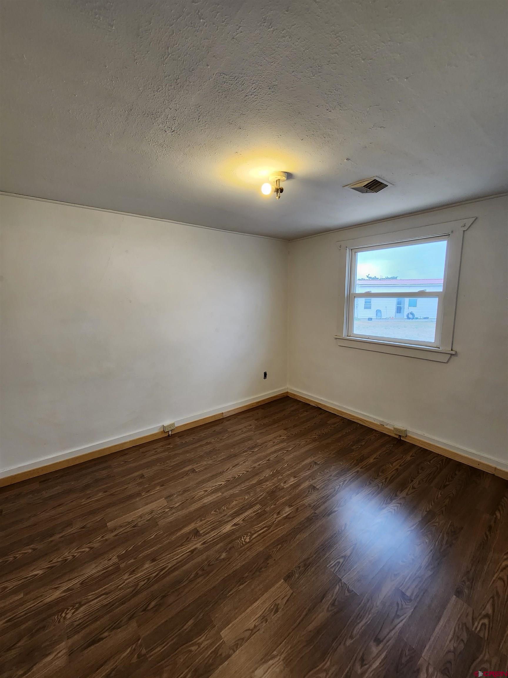 11977 US Highway 285 Center, CO 81125 - Photo 6 of 16 an empty room with wooden floor and windows