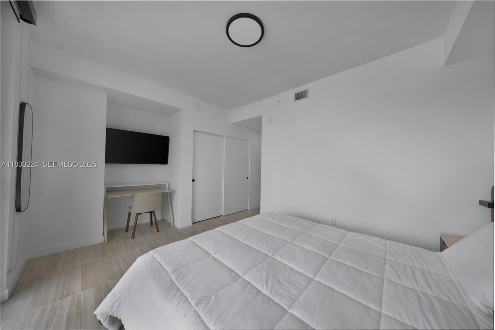 580 72nd Street, Unit 910 Miami Beach, FL 33141 - Photo 49 of 60 a bedroom with a bed and a flat screen tv