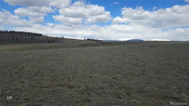 a view of a field and mountains in the background