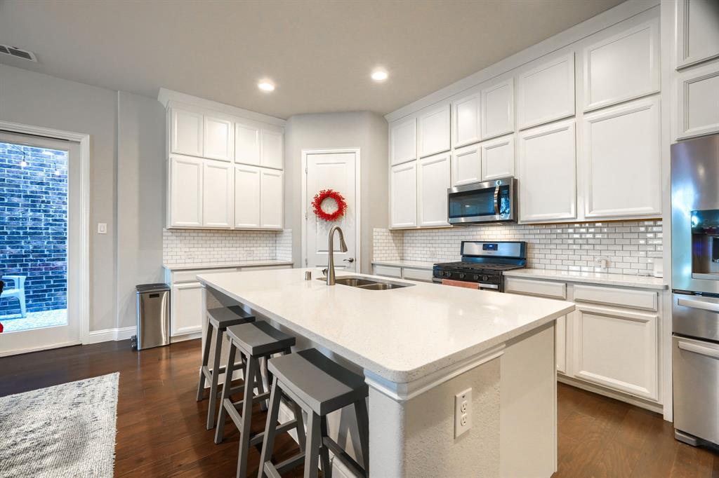 1436 Pebble Way Allen, TX 75013 - Photo 11 of 35 a kitchen with a sink a stove a microwave and white cabinets