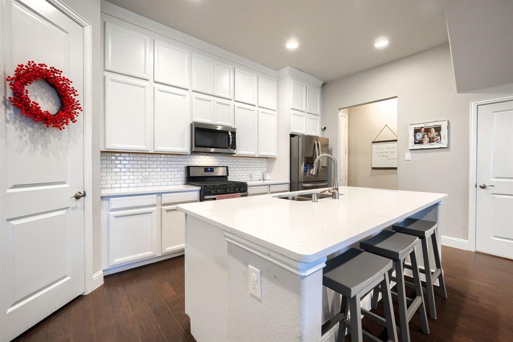 1436 Pebble Way Allen, TX 75013 - Photo 12 of 35 a kitchen with a microwave a stove a sink dishwasher a refrigerator with a dining table and chairs