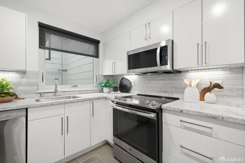a kitchen with cabinets stainless steel appliances a sink and a microwave