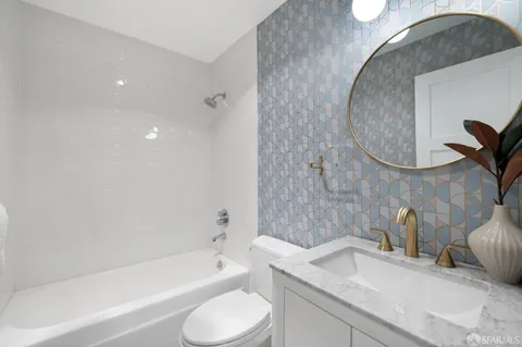 a bathroom with a granite countertop sink toilet and bathtub