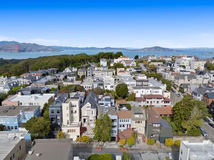 an aerial view of residential houses with outdoor space and parking