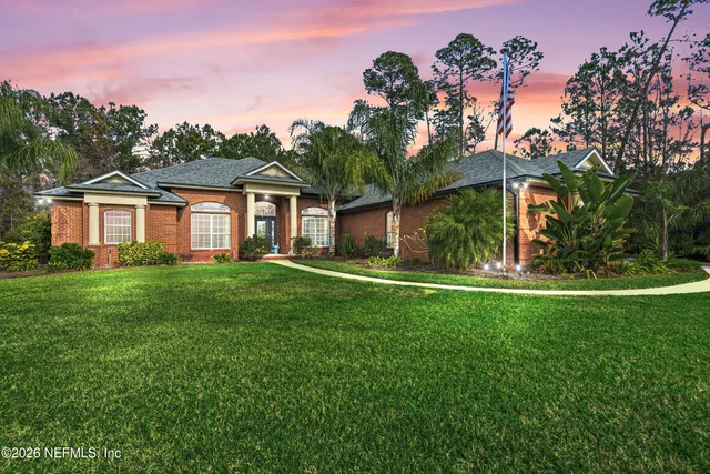 a front view of a house with a yard and potted plants