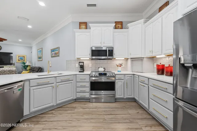 a kitchen with sink cabinets and stainless steel appliances