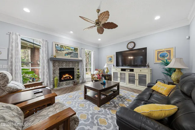 a living room with furniture a flat screen tv and a fireplace