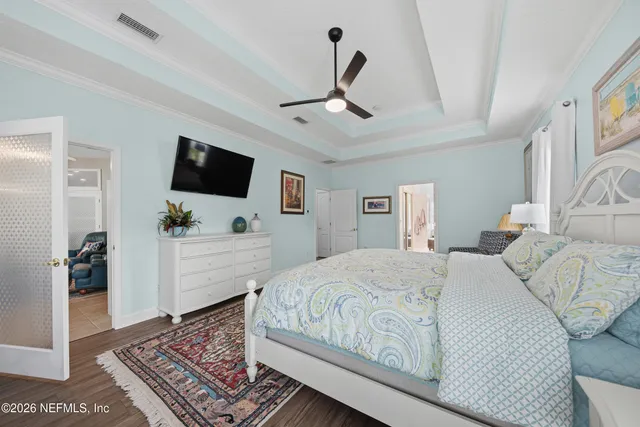 a bedroom with a large bed a flat tv screen and a rug