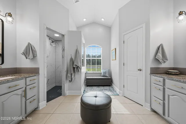 a spacious bathroom with a granite countertop sink a toilet a mirror and shower