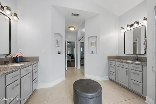 a spacious bathroom with a granite countertop sink a toilet and a mirror