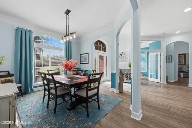 a dining room with furniture window and wooden floor