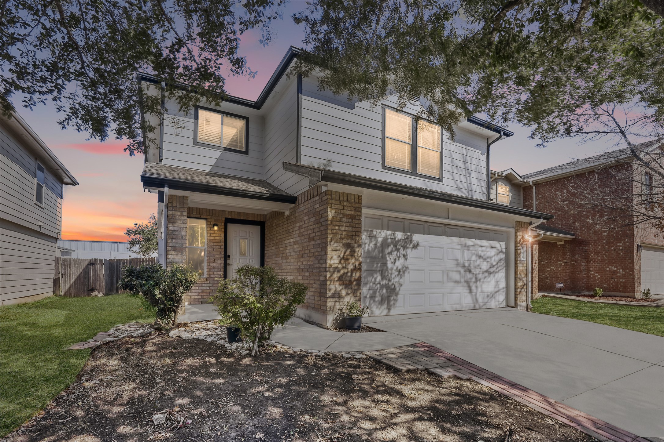 Traditional-style home featuring brick siding, an attached garage, and concrete driveway