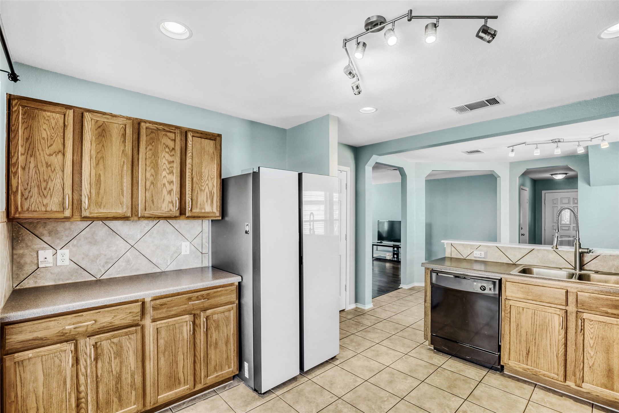 5624 Colinton Avenue Austin, TX 78754 - Photo 16 of 38 Kitchen featuring freestanding refrigerator, dishwasher, backsplash, light countertops, and track lighting