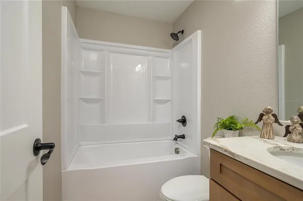 a bathroom with a granite countertop sink and a toilet