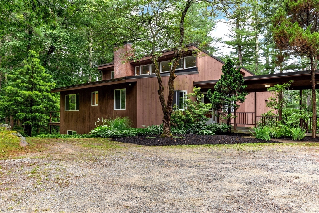 738 Lowell Road Groton, MA 01450 - Photo 1 of 30 a front view of a house with a garden and tree