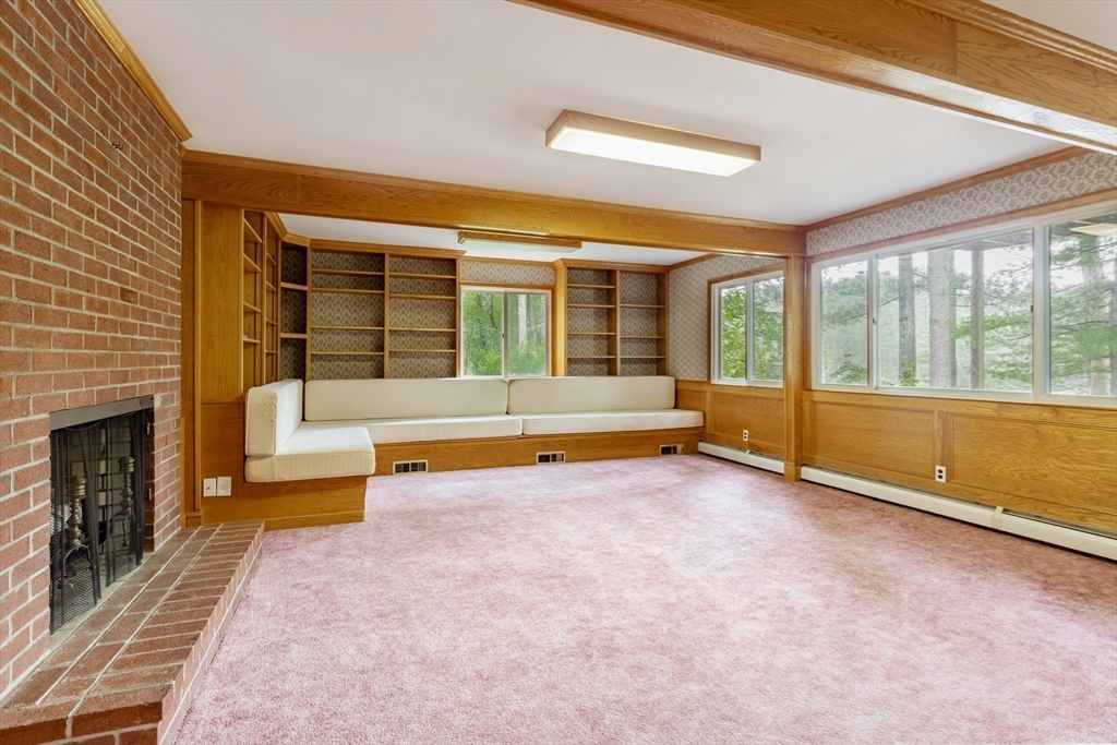 738 Lowell Road Groton, MA 01450 - Photo 15 of 30 a view of an empty room with a fireplace and a large window