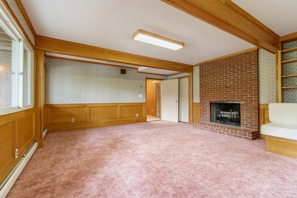 738 Lowell Road Groton, MA 01450 - Photo 16 of 30 a view of an empty room with a fireplace and a window