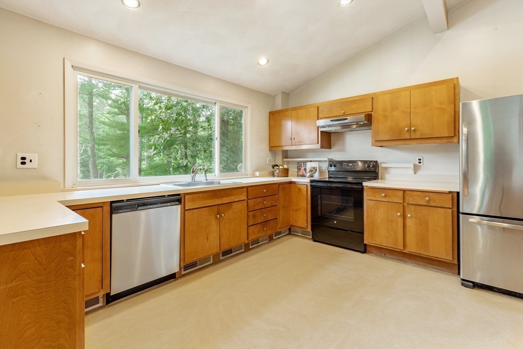 738 Lowell Road Groton, MA 01450 - Photo 9 of 30 a kitchen with a stove a sink dishwasher a refrigerator with white cabinets and wooden floor