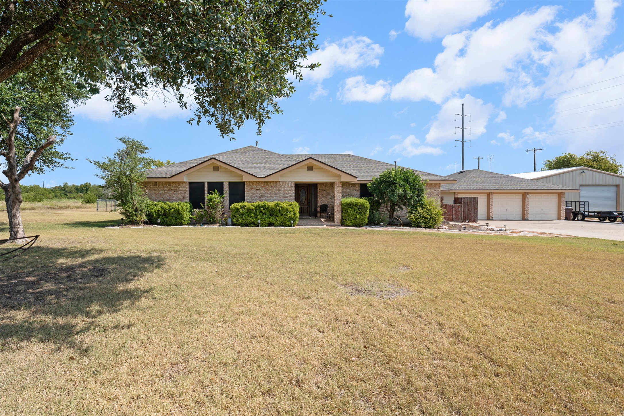 1512 Panther Loop Pflugerville, TX 78660 - Photo 2 of 40 A classic brick exterior with a welcoming entryway, complemented by a detached three-car garage and additional workshop space.