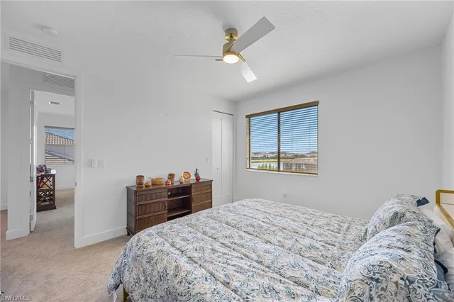 a bathroom with a toilet a sink a mirror a window and vanity