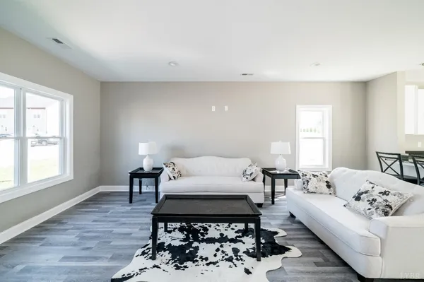 a living room with furniture a wooden floor and a large window