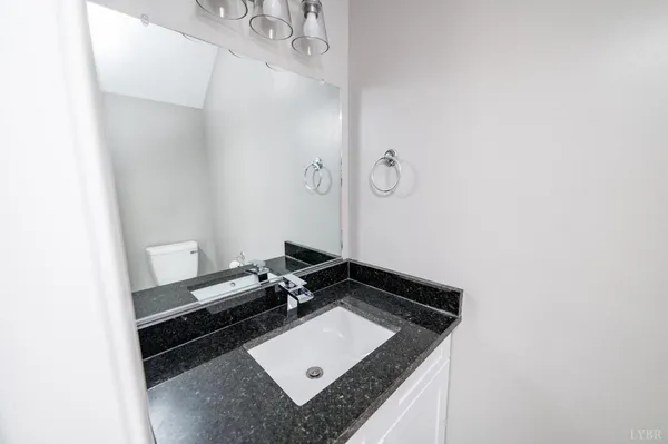 a bathroom with a granite countertop sink and cabinets