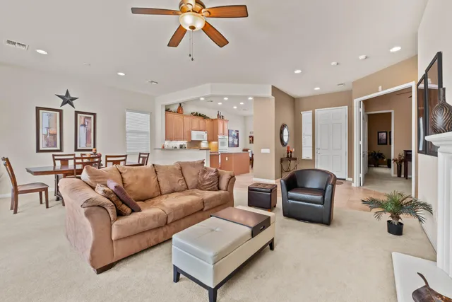 a living room with furniture kitchen view and a chandelier