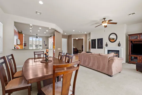 a living room with furniture a clock and a view of kitchen