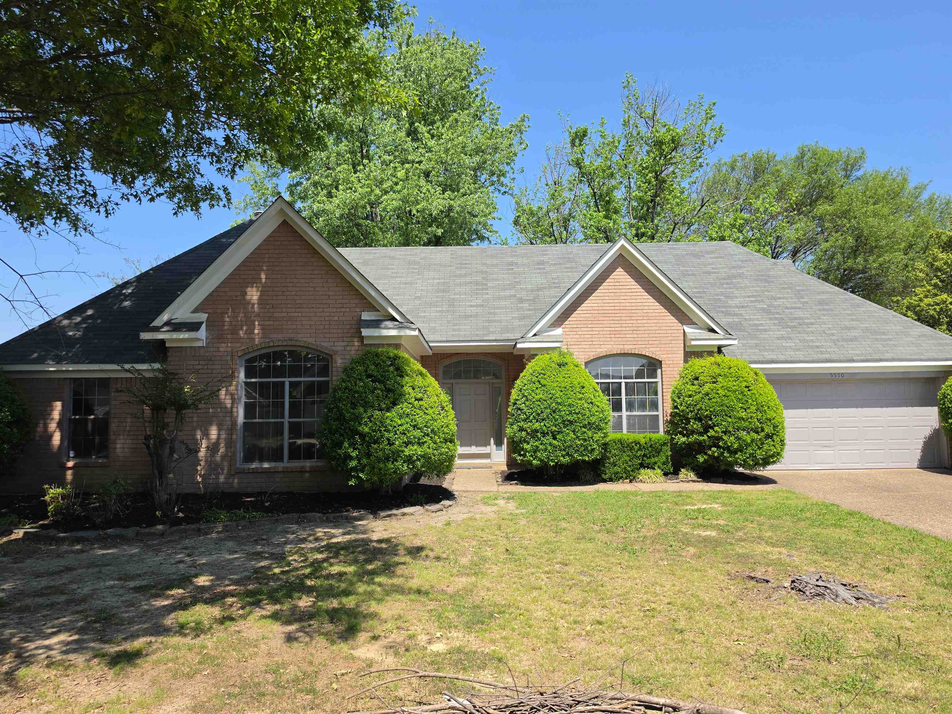 5570 Patsy Circle West Memphis, TN 38125 - Photo 1 of 22 View of front of house featuring a front yard, brick siding, an attached garage, and driveway