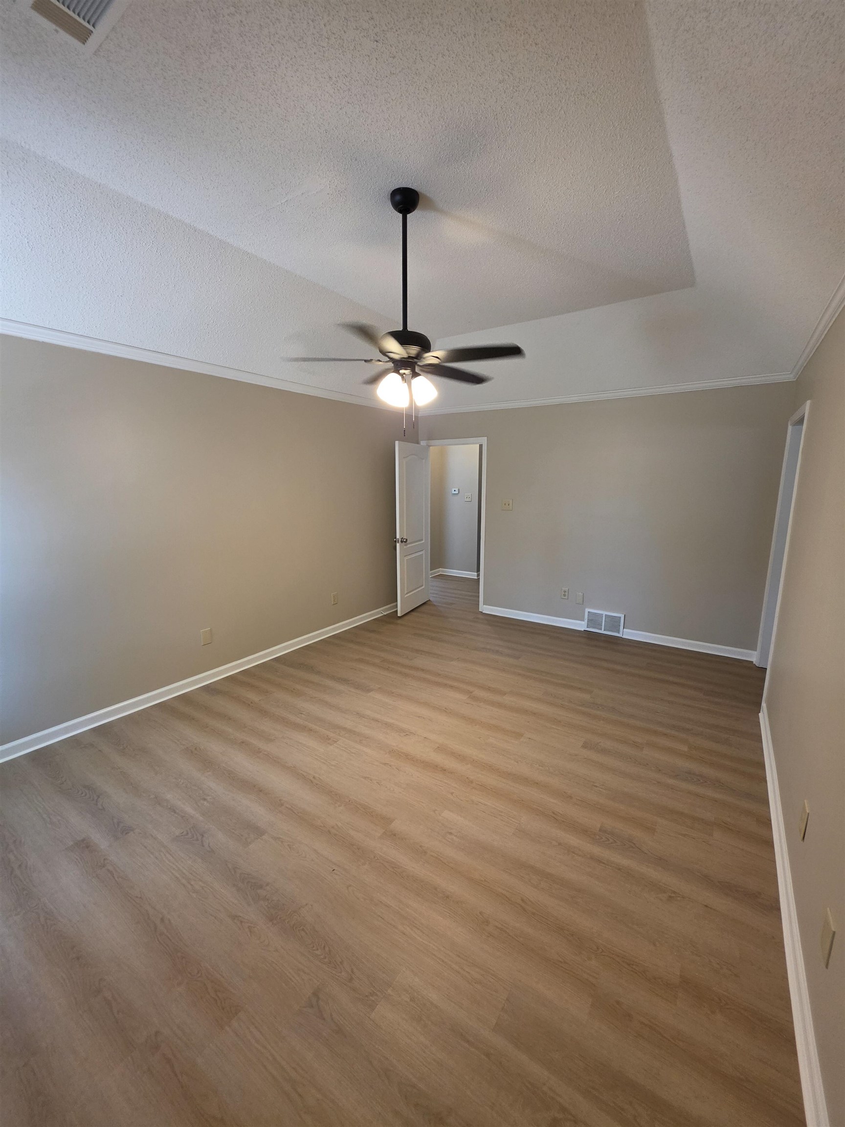 5570 Patsy Circle West Memphis, TN 38125 - Photo 16 of 22 Primary Bedroom with a textured ceiling, light wood-style flooring, ceiling fan, and ornamental molding