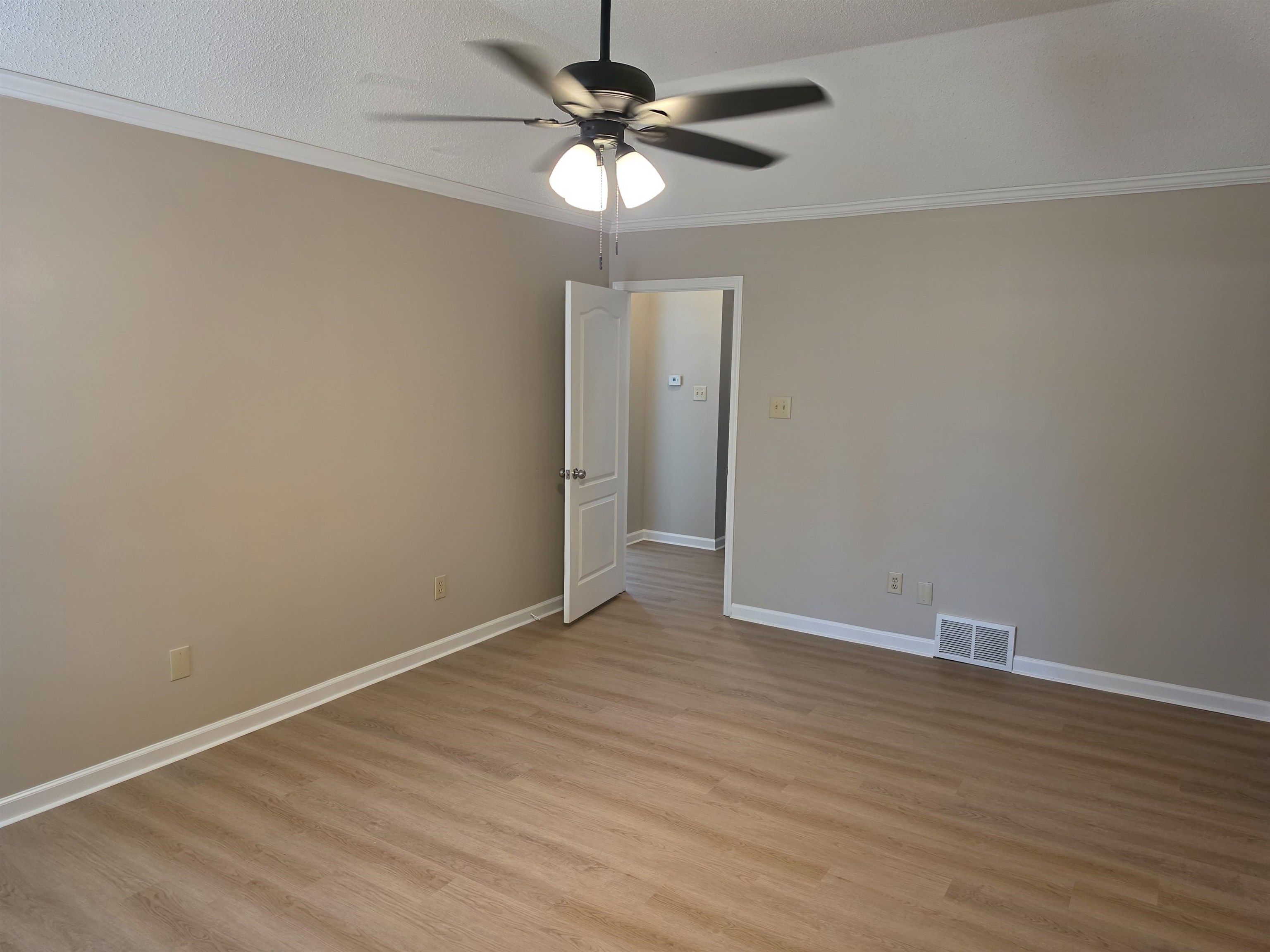 5570 Patsy Circle West Memphis, TN 38125 - Photo 18 of 22 Crown molding, a ceiling fan, and light wood-style flooring, new paint
