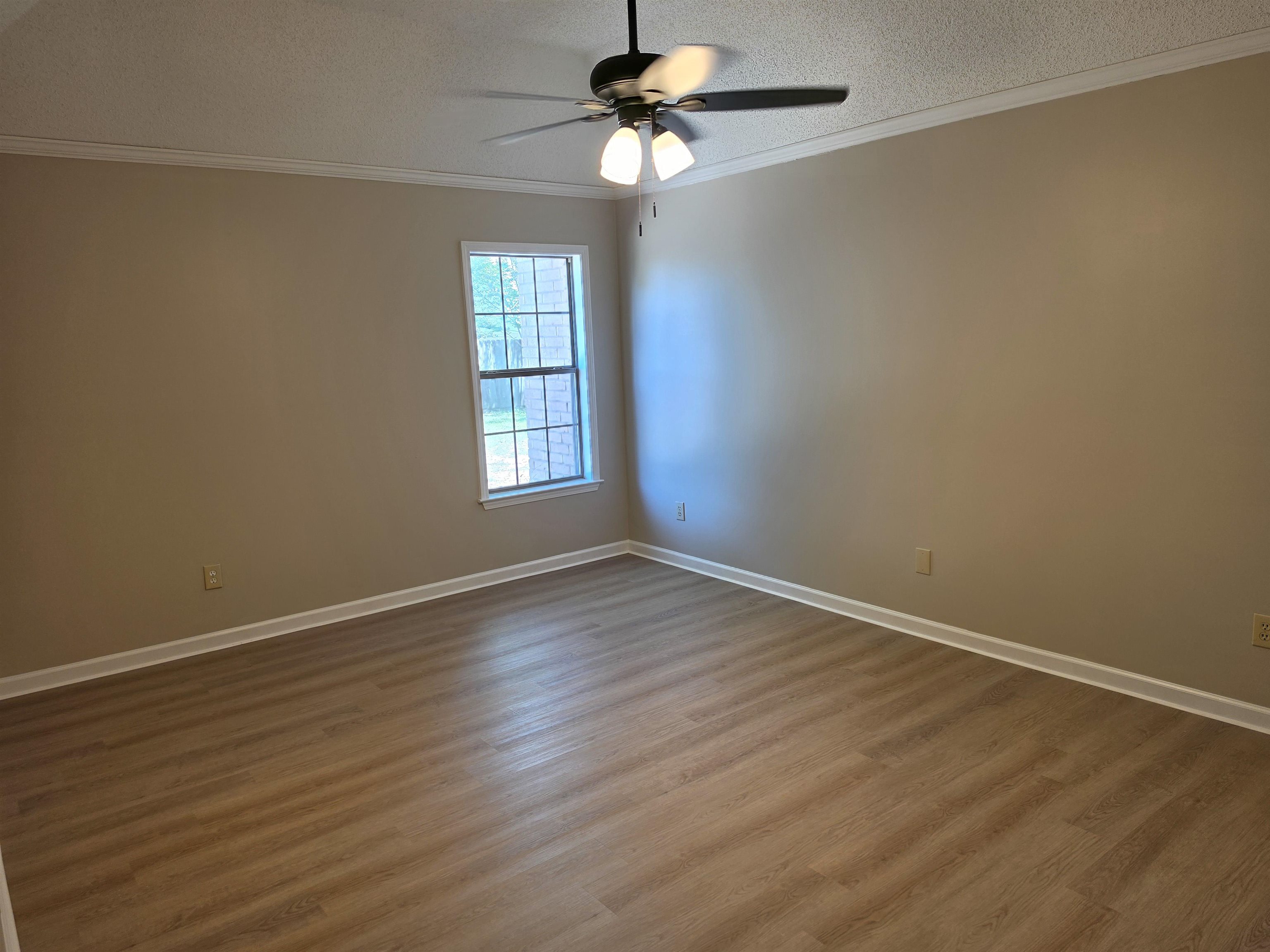 5570 Patsy Circle West Memphis, TN 38125 - Photo 19 of 22 Another Bedroom with crown molding, light wood-style floors, a textured ceiling, and a ceiling fan