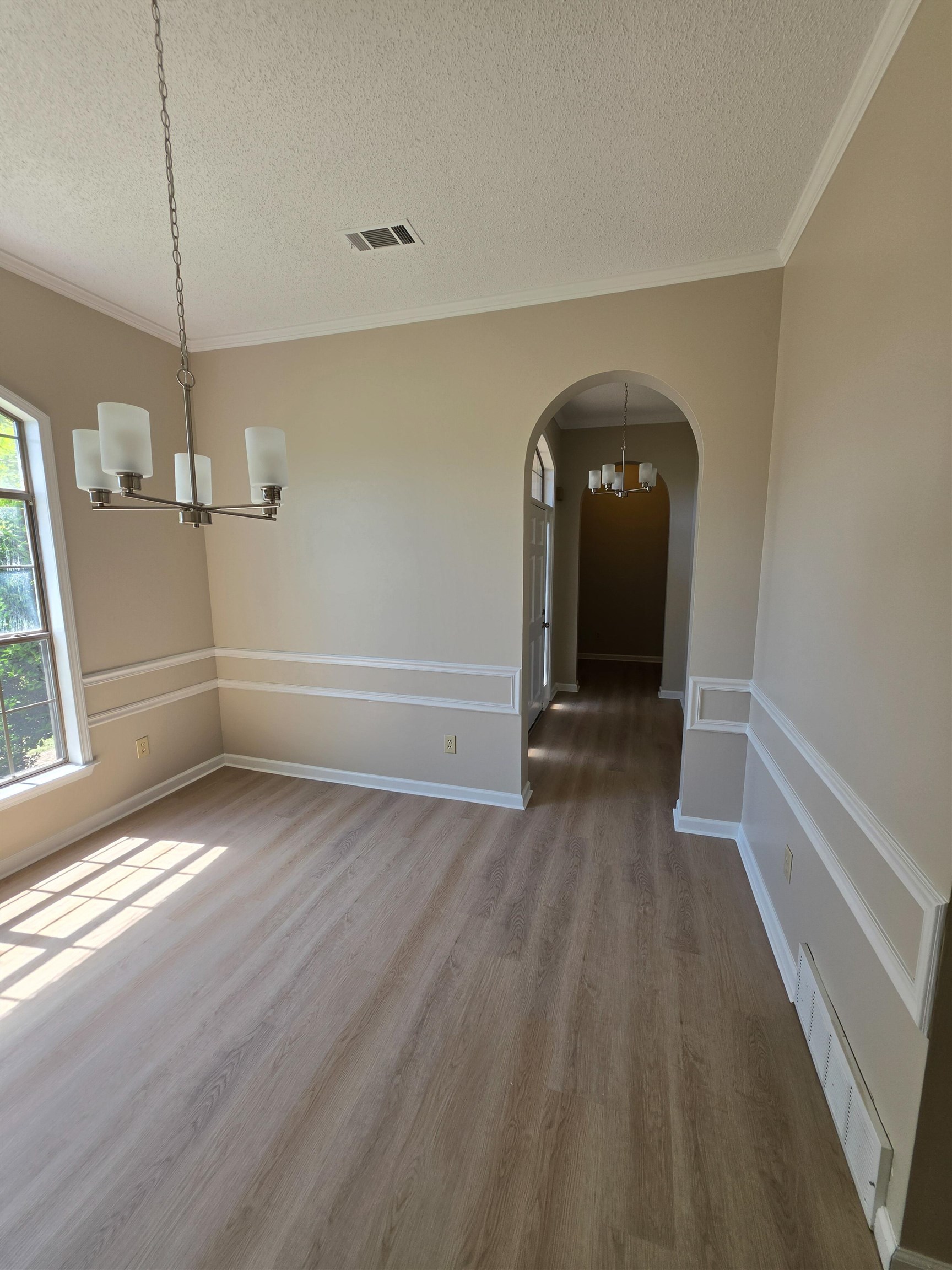 5570 Patsy Circle West Memphis, TN 38125 - Photo 6 of 22 Dining area with suspended lighting, arched walkways, a textured ceiling, light wood finished floors, and ornamental molding and beautiful large window.
