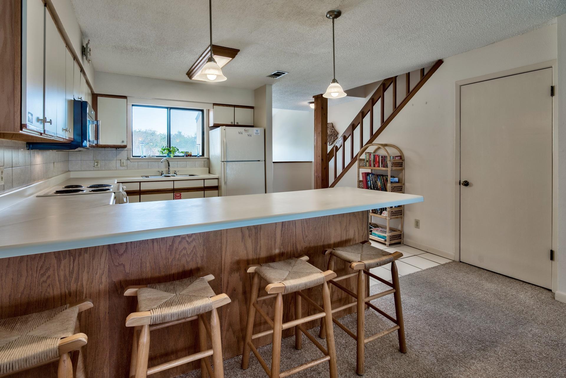 214 Blue Mountain Road, Unit 122 Santa Rosa Beach, FL 32459 - Photo 13 of 32 a kitchen with a table chairs refrigerator and microwave