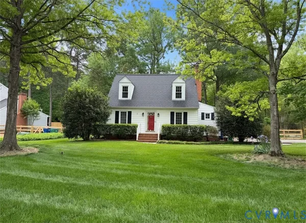 a view of a big house with a big yard and large trees