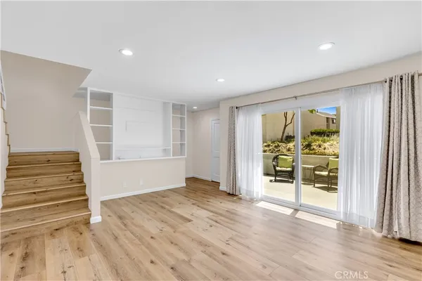 a view of empty room with wooden floor and ceiling fan