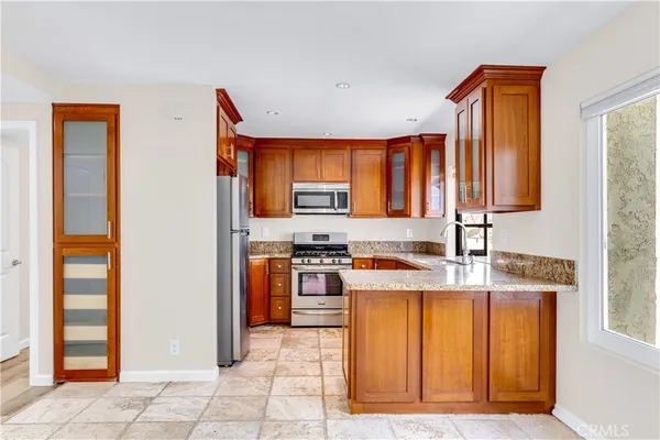 a kitchen with granite countertop cabinets stainless steel appliances and a sink