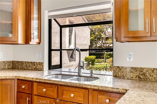a view of a kitchen with stainless steel appliances granite countertop a refrigerator and a stove top oven